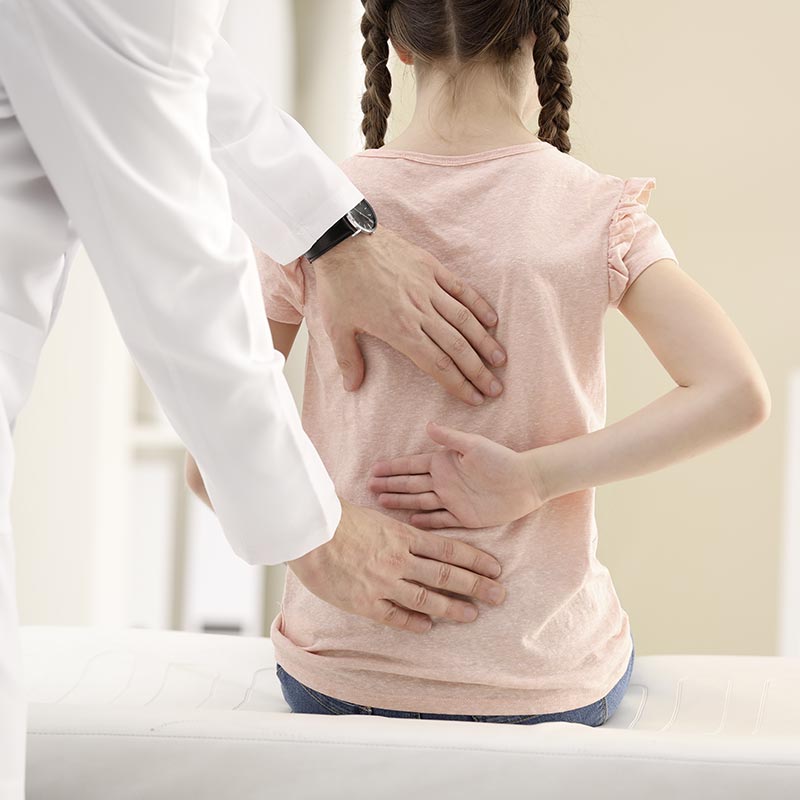 Mädchen wird wegen Fehlstellung der Wirbelsäule und des Beckens in der Physiotherapie behandelt.